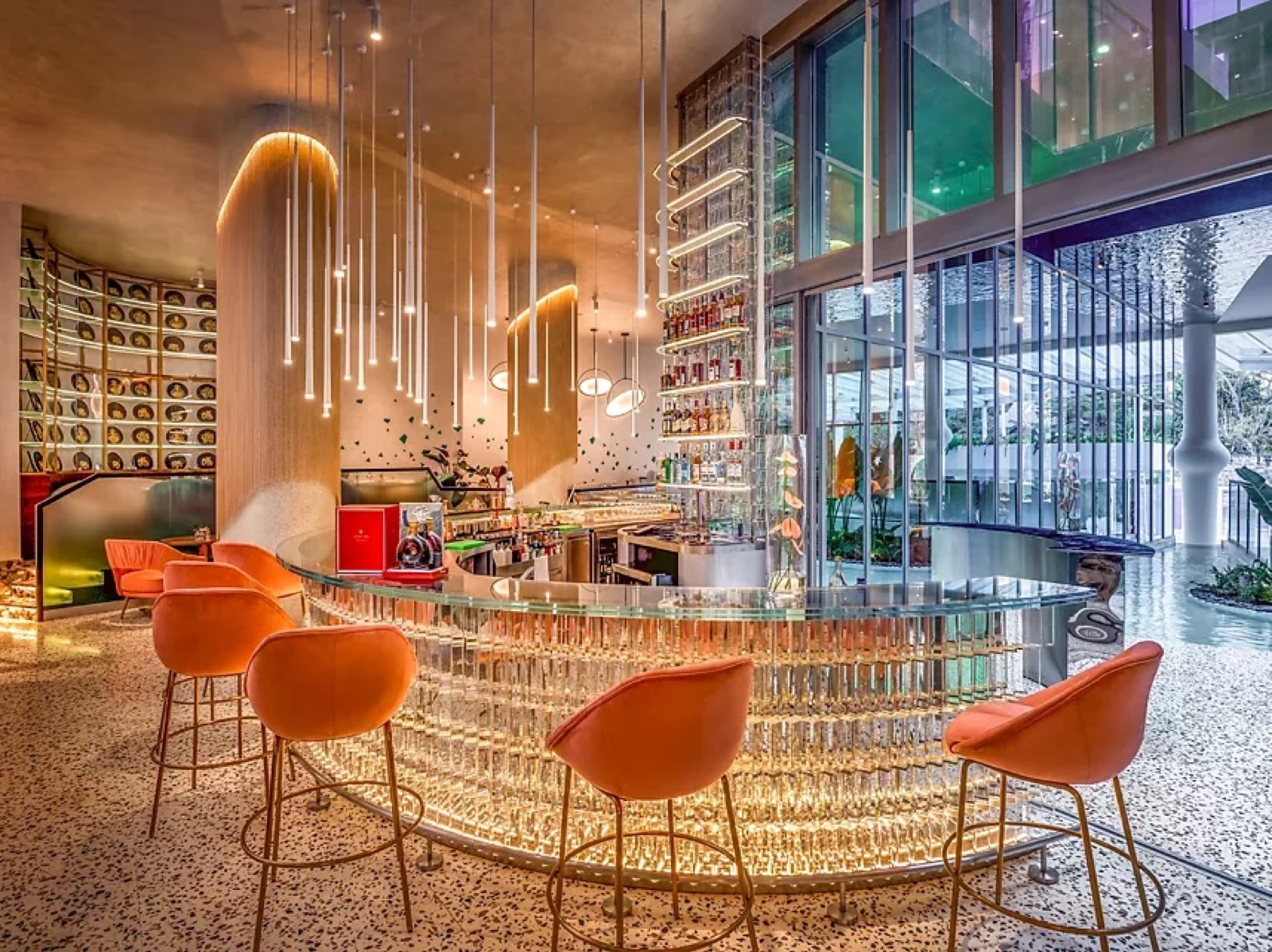 Curved glowing bar with orange stools at Gem Forest