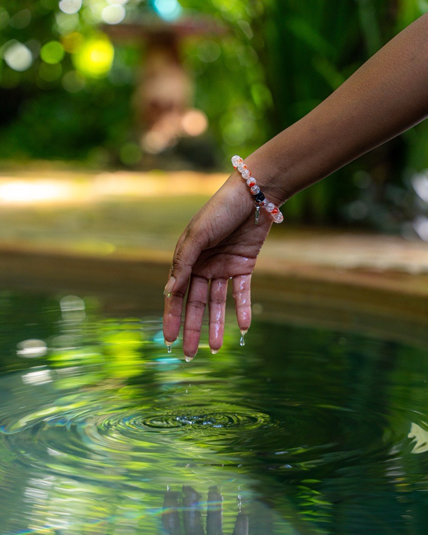 Hand touching the pool water at Kaya Imani