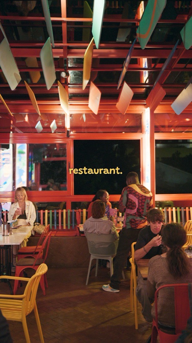 Wide view of the colorful Mammam dining room full of guests