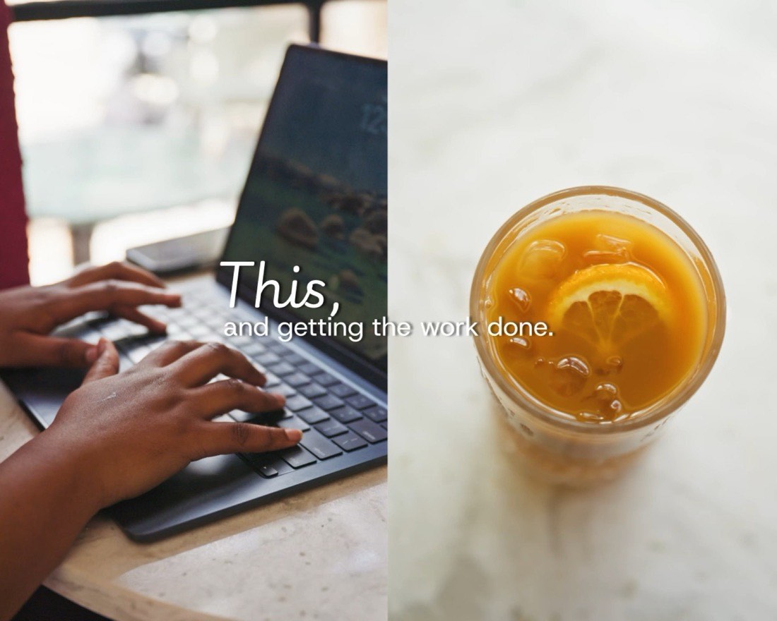 Working on a laptop next to an iced drink at Okia