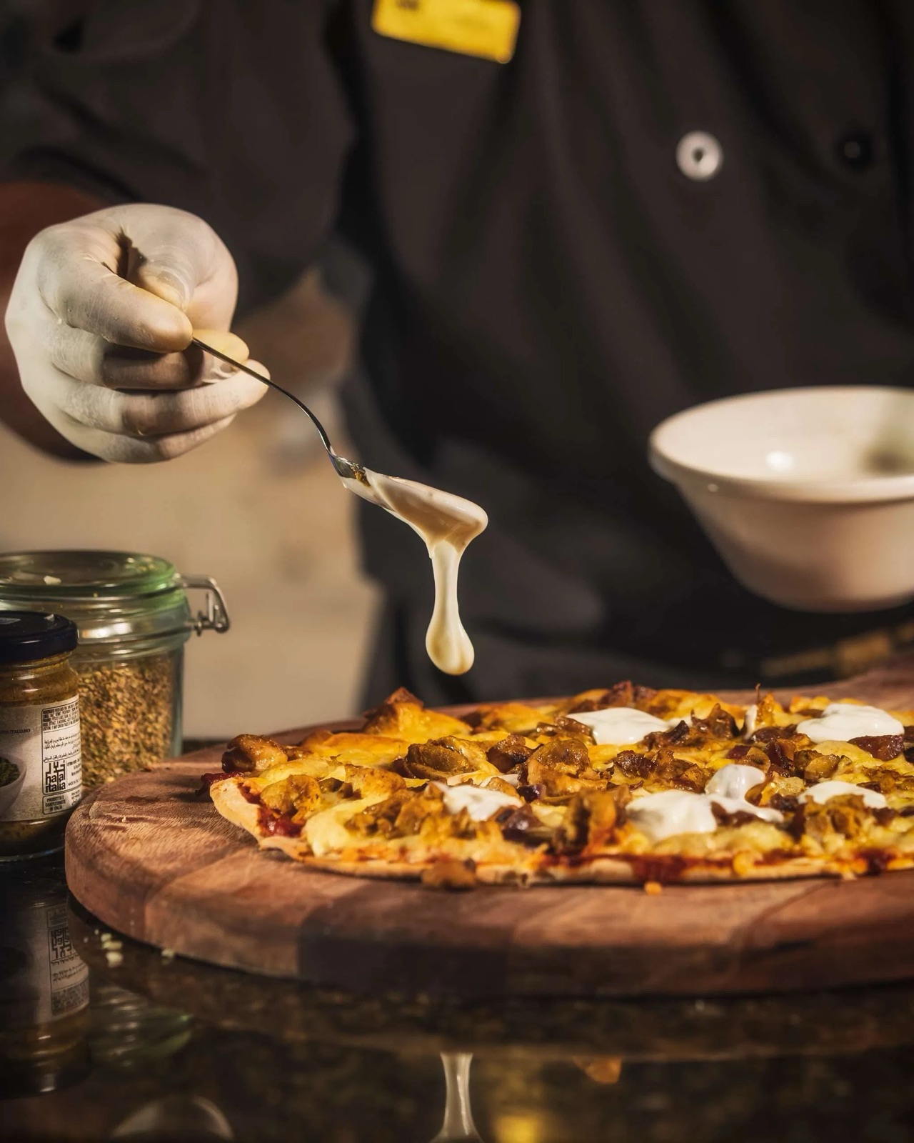 Chef finishing a pizza with honey