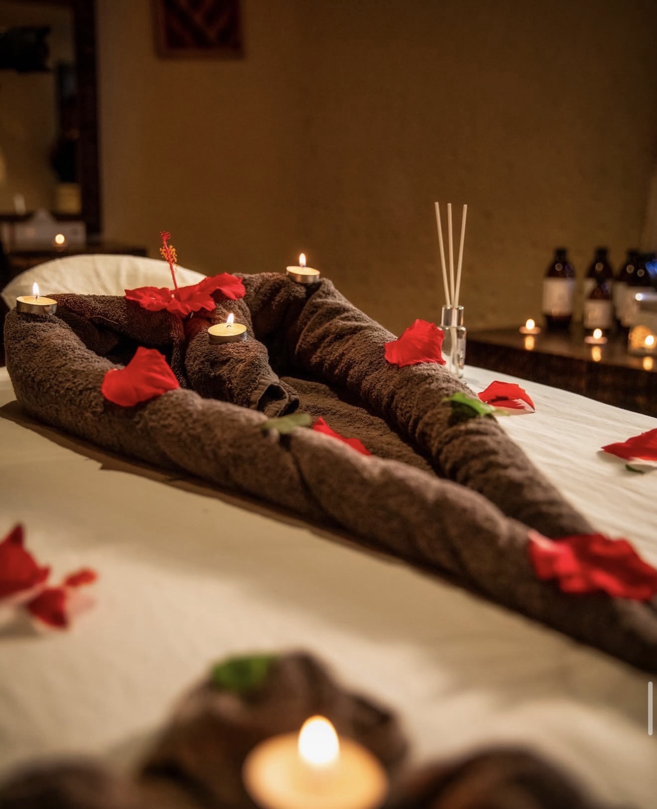 Spa table dressed with towels, petals and candles